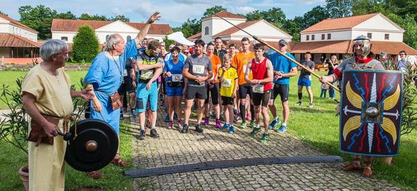 Erster Roemerlauf rund um die Villa Borg: Start auf "roemisch": G&Atilde;&OElig;nter Wolff (2.v.l.) laesst das Tuch fallen, Heiner Thul (l) schlaegt den Gong und Gerd Schmitt wacht mit der Lanze (r).
Foto: Rolf Ruppenthal/ 29. Juni 2016