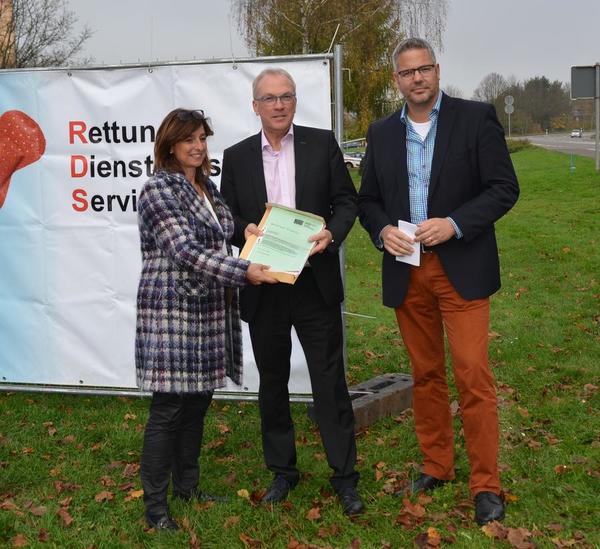 Landr&auml;tin Daniela Schlegel-Friedrich &uuml;berreicht Landrat Udo Recktenwald in Beisein von B&uuml;rgermeister Jochen Kuttler die Baugenehmigung